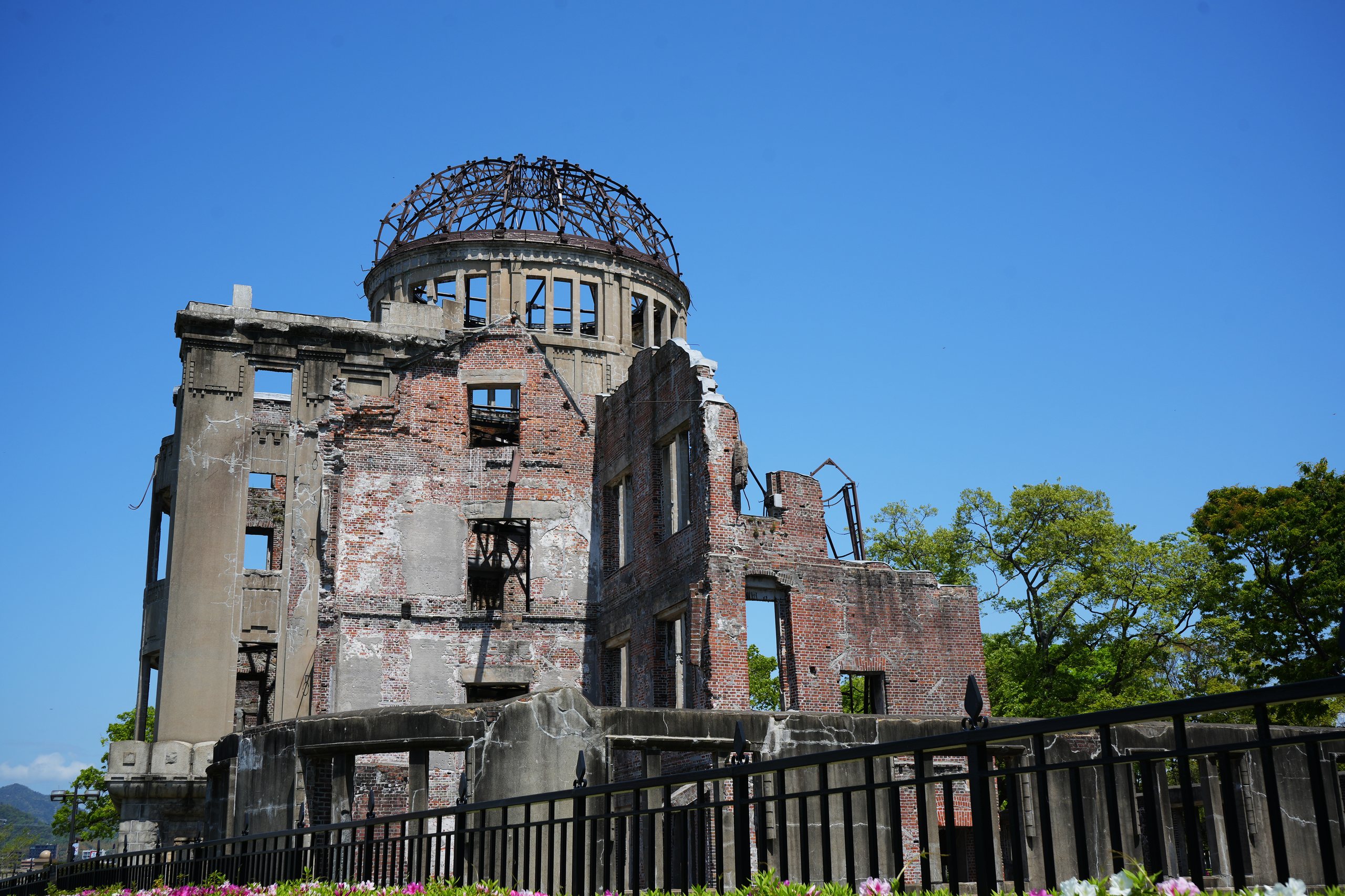 The ruined Atomic Bomb Dome in Hiroshima against a deep blue sky