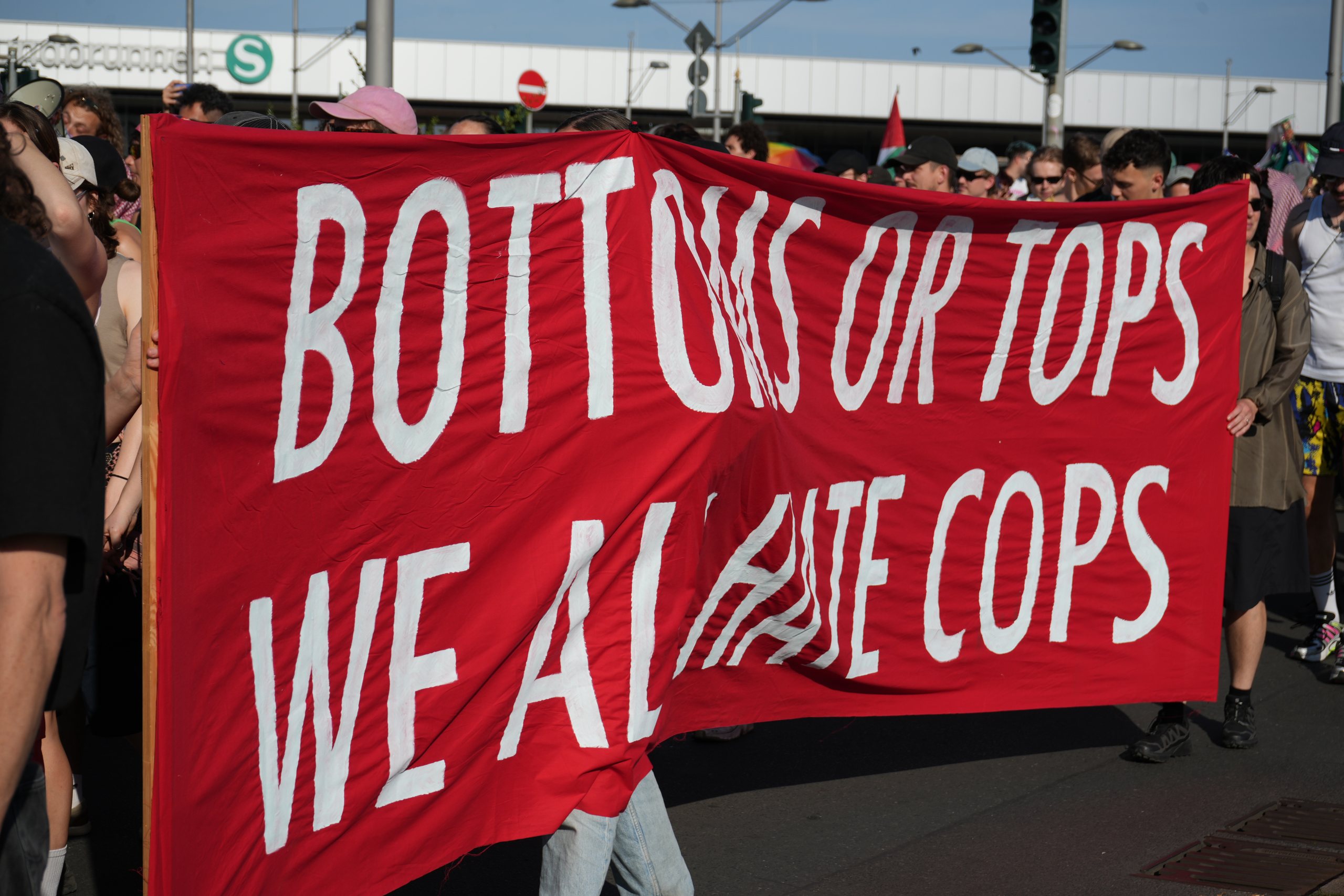 Red banner reading Bottoms or tops, we all hate cops at Queer Pride Berlin 2026